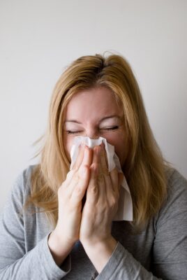 woman sneezing because of office allergens