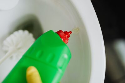 applying toilet bowl cleaner for Houston office cleaning services