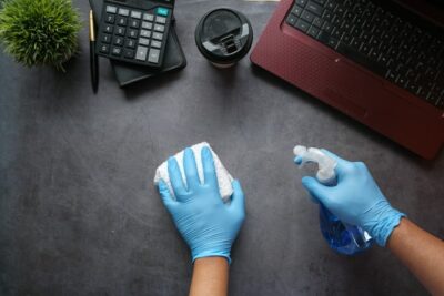 Person wiping off desk for Houston office cleaning services