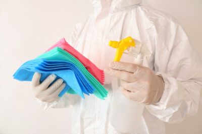 person holding rags and cleaning solution for Houston office cleaning services