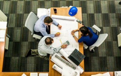 people sitting at workplace desk surrounded by carpet that needs Houston commercial cleaning services