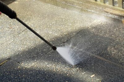 Person pressure washing walkway for exterior Houston commercial cleaning 